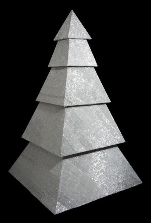 Custom faceted silver-glitter tree sculpture against a black backdrop — bespoke holiday installation for Rihanna